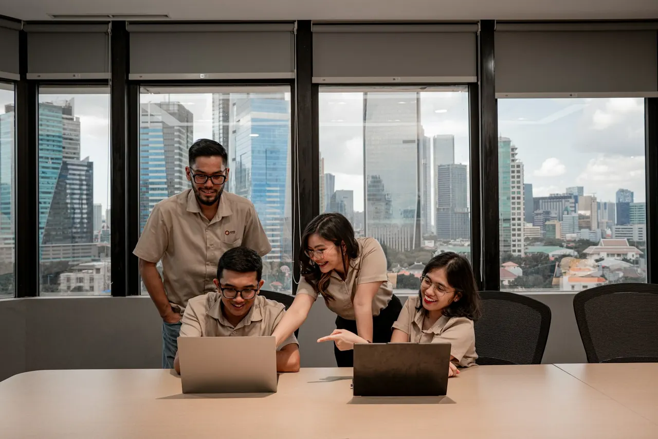 Colleagues collaborating around laptops in a bright modern office